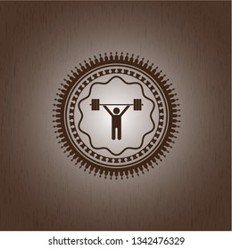 weightlifting icon inside wooden emblem