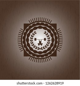 weightlifting inside of crown icon inside badge with wood background