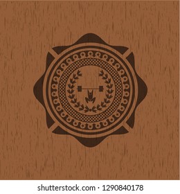 weightlifting inside of crown icon inside badge with wooden background