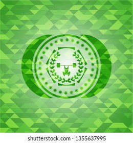 weightlifting inside of crown icon inside green emblem with triangle mosaic background