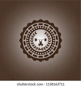 weightlifting inside of crown icon inside wooden emblem