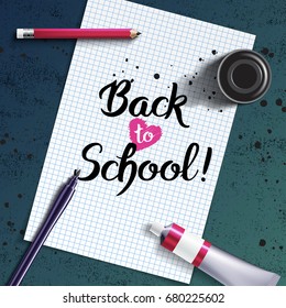 Welcome Back to School hand drawn lettering with calligraphy mock-up with brush pen, sharp pencil, paint tube and black ink bottle on the background of white sheet of paper and grunge chalk board