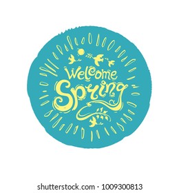 Welcome spring. Round stamp of turquoise color with a yellow inscription. Vector handwriting template with inscription and birds with twigs and rays of the sun isolated on white background.
