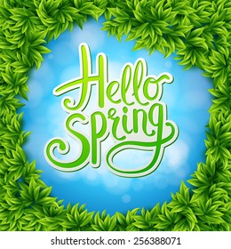 Welcoming Springtime Concept - Artistic Hello Spring Text on Abstract Sky Blue Background Surrounded by Green Fresh Leaves