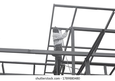 The welder is welding the roof of the house.