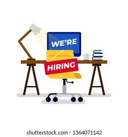 We're Hiring sign hung on the chair of empty office employee workplace.