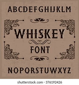Whiskey label font and sample label design with decoration and ribbon. Vintage font. Whiskey font. Fine label font. Handcrafted font. Decoration font. Font style. Retro font. Old font. Stylized font.