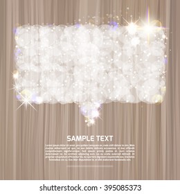 White air speech bubble rectangular form with glitters and sparkles on a wooden surface. 