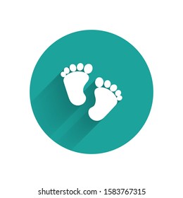 White Baby footprints icon isolated with long shadow. Baby feet sign. Green circle button. Vector Illustration