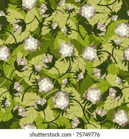 White berries of a raspberry on green leaves a seamless background