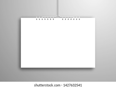A white blank calendar or notebook on a spiral hangs on a thread near the wall. Realistic mockup for design