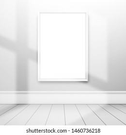 A white blank frame for a picture or poster on the wall illuminated by sunlight from the window in empty white room. Mockup for gallery design
