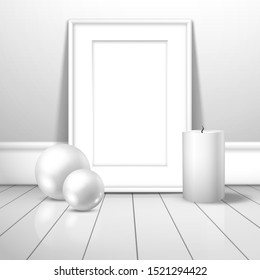 A white blank frame for a picture or poster and two white balls and a wax candle stands near the wall on the boards. Mockup for gallery design with shadow