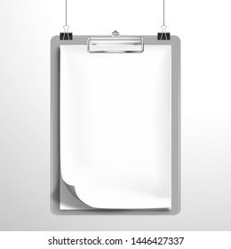 A white blank notebook or an album with a bent top sheet is clamped in the clipboard and hanging on the clips. Mockup for design
