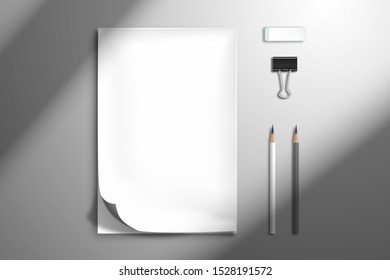 White blank notebook or sketchbook with a curved top sheet, two pencils, binder and an eraser. Flat lay mockup with shadow from window