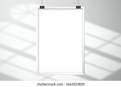 White blank picture frame hang on clips. Light from arched windows on a white floor or surface. Template for design