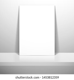 A white blank sheet of paper or card stands near the wall on the shelf. Mockup for design with shadow