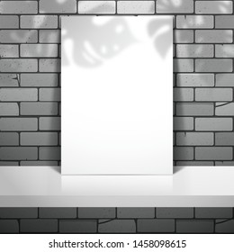 A white blank sheet of paper or card stands near the brick wall on the shelf. The shadow of the leaves of the Monstera plant is on top. Mockup for gallery design