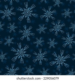 White and blue snowflakes on blue background seamless pattern