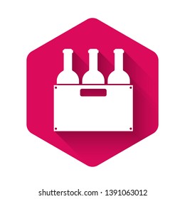 White Bottles of wine in a wooden box icon isolated with long shadow. Wine bottles in a wooden crate icon. Pink hexagon button. Vector Illustration