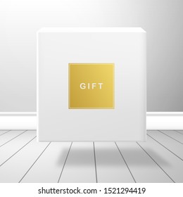 A white box falls on the plank floor. Gold label with the inscription Gift