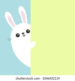 White bunny rabbit holding green wall signboard. Cute cartoon funny animal hiding behind paper. Happy Easter symbol. Peekaboo. Flat design. Pastel blue color background. Vector illustration