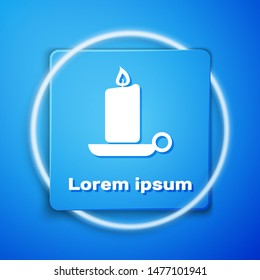 White Burning candle in candlestick icon isolated on blue background. Old fashioned lit candle. Cylindrical candle stick with burning flame. Blue square button. Vector Illustration