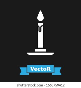 White Burning candle in candlestick icon isolated on black background. Cylindrical candle stick with burning flame.  Vector Illustration