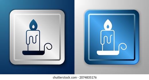 White Burning candle in candlestick icon isolated on blue and grey background. Cylindrical candle stick with burning flame. Silver and blue square button. Vector
