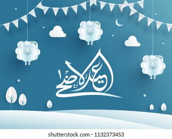 White calligraphy of Eid Al Adha Mubarak text on shiny blue background decorated with paper cut out of landscape, hanging sheep, cloud and bunting flag for festival celebration.