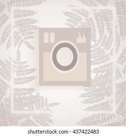white camera in white and gray tropical leaves backdrop
