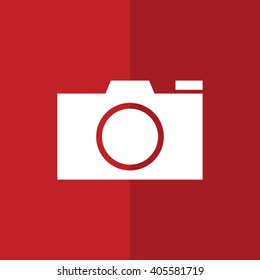 White camera vector icon. Red background