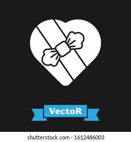 White Candy in heart shaped box and bow icon isolated on black background. Valentines Day.  Vector Illustration
