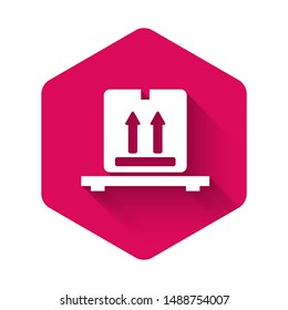 White Cardboard boxes on pallet icon isolated with long shadow. Closed carton delivery packaging box with fragile signs. Pink hexagon button. Vector Illustration