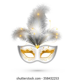 White carnival mask with golden glitter decoration and realistic silver feathers