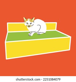 a white cat with brown spots on the ears sitting on a rectangular object like a chair