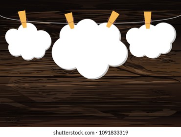 White clouds of paper hang on a rope with clothespins on the wooden background. Vector. Free space for text or advertising