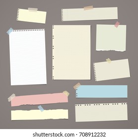 White and colorful striped note paper, copybook, notebook sheet stuck with adhesive tape on dark brown background.