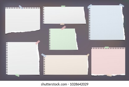 White and colorful torn, lined, and squared note, notebook paper strips for text stuck with sticky tape on dark background.