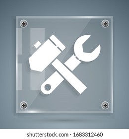 White Crossed hammer and wrench spanner icon isolated on grey background. Hardware tools. Square glass panels. Vector Illustration