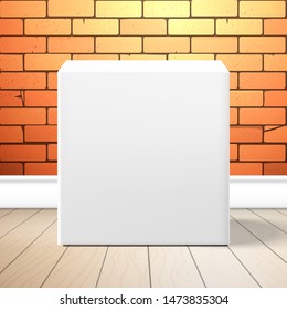A white cubic box is near the red brick wall on the floor. Front view. Realistic mockup for design with shadow
