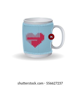 White cup with a blue knitted cover. On the cover design with red heart and a button. Vector winter illustration to Valentine's Day. Isolate.