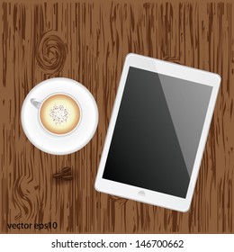 White digital tablet on wood with a cup of coffee