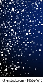White dots Christmas background. Subtle flying snow flakes and stars on dark blue background. Amusing winter silver snowflake overlay template. Original vertical illustration.
