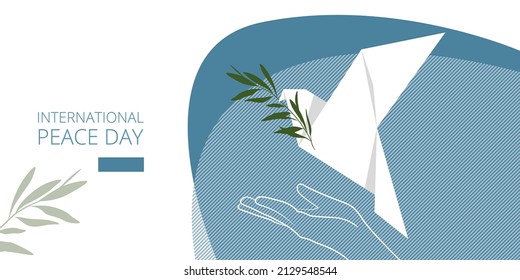 The white dove of peace flies from the palm of the hand with an olive branch in its beak. Origami. A symbol of peace. Landing page template, presentation, banner for the International Day of Peace.