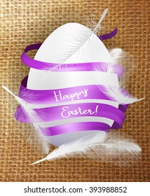 White easter egg with purple ribbon on the textile background