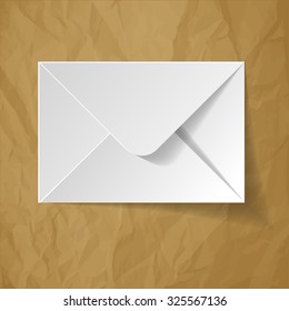 White envelope on a crumpled paper brown background.