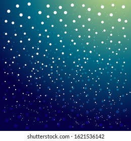 white falling snow against a beautifully colored gradient blue sky in the winter season before Christmas