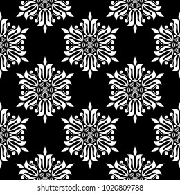 White floral ornament on black background. Seamless pattern for textile and wallpapers