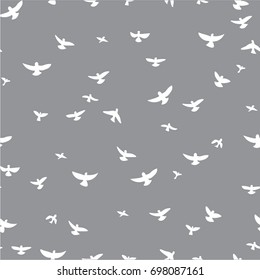 White flying birds on a gray background. Seamless pattern. Modern stylish texture. Monochrome  graphic design. Freehand drawing vector.
